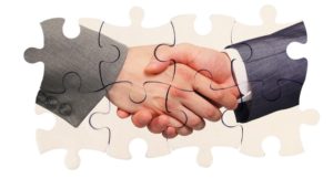 shaking hands inside puzzle pieces shaking hands inside puzzle pieces